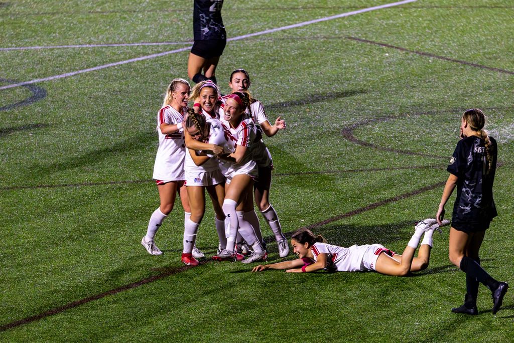 Photo: Women's soccer players embrace each other on field during a recent match