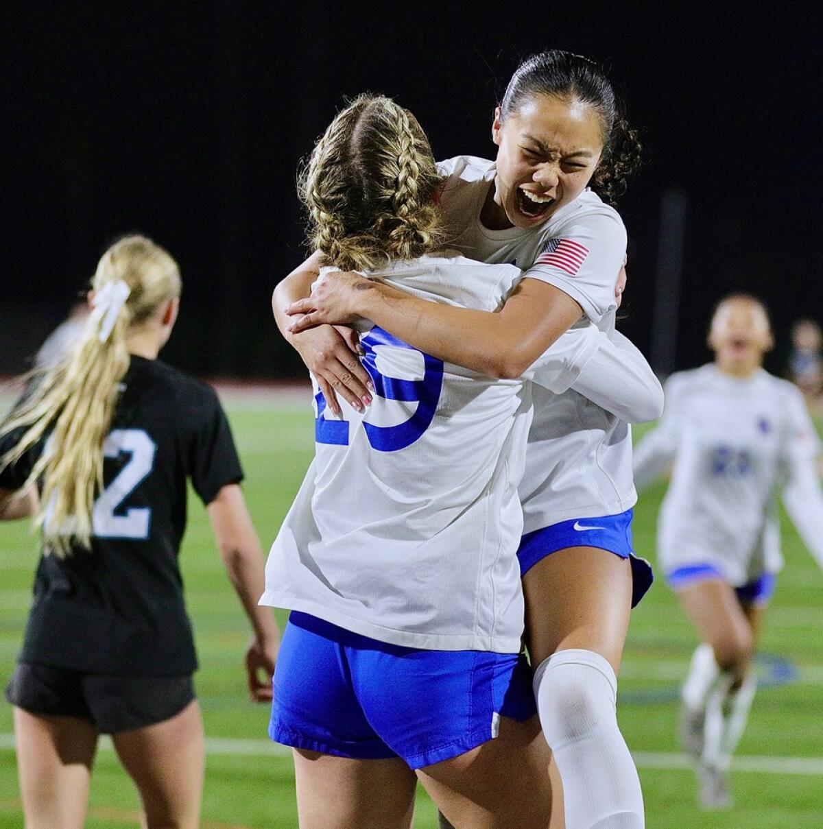 Felicity Nguyen leaps into the arms of Santa Margarita girls' soccer teammate Cora Fry after scoring a goal.