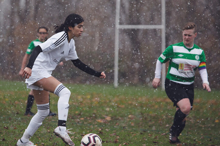Women playing soccer in the rain.