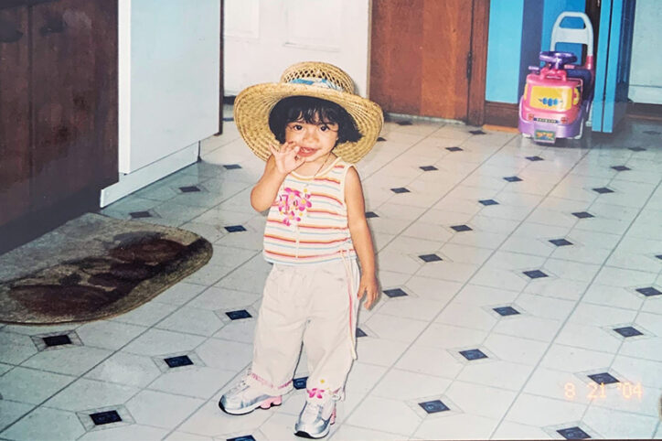 A smiling toddler waves to the camera.