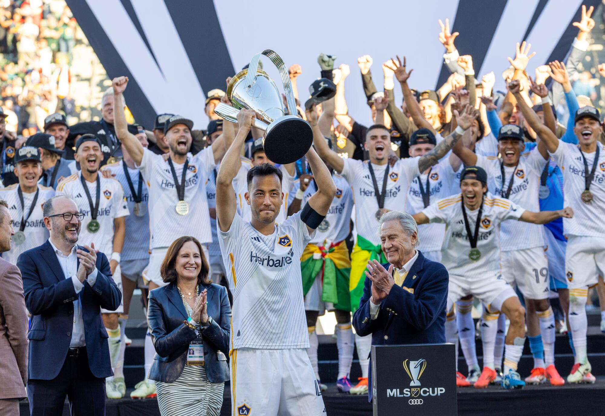 Galaxy defender and team captain Maya Yoshida lifts the MLS Cup after the team's championship win.
